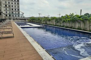 a large swimming pool with palm trees and a building at Apto, Wi-Fi, Piscina, Ótima localização e vaga de garagem em Osasco in Osasco