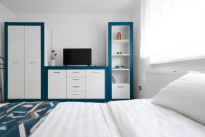 - une chambre avec un lit, une télévision et un miroir dans l'établissement BIUTI, à Târgu-Mureş