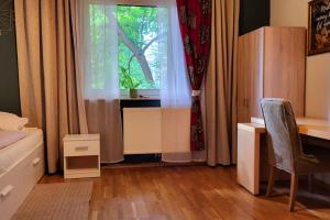 a bedroom with a window and a desk and a chair at Colourful 2.5 Bedroom With Large Balcony & Garden. in Prinzersdorf