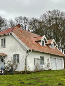 une maison blanche avec un toit rouge dans l'établissement Östragården, à Sölvesborg