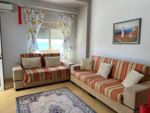 a living room with two couches and a window at Sea view apartment, Himara in Himare