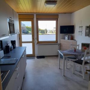 a kitchen with a table and a dining room at Bichlhof Bärfra Ferienwohnung Hunsrück in Morbach