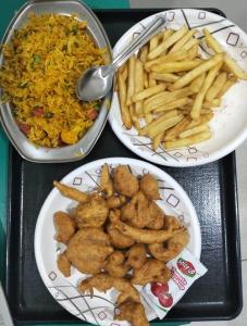 trois assiettes de nourriture sur un plateau avec des frites dans l'établissement HOTEL E CLASSICO, à Bhavnagar