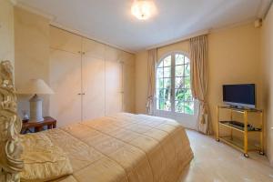 Un dormitorio con una cama grande y un televisor. en Villa de luxe à Cap-d'Ail, en Saint-Antoine 31 fotos más