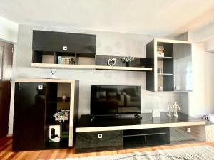 a living room with a flat screen tv on a wall at Valcea Northside Spacious Apartment in Râmnicu Vâlcea