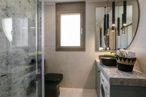 een badkamer met douche, wastafel en spiegel bij APARKTION THE ZEPHYRUS STUDIO in Lixouri +5 foto's