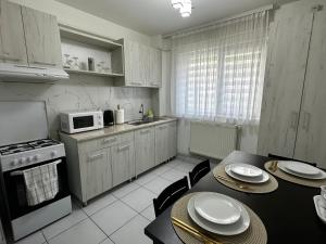 uma cozinha com uma mesa e cadeiras e um micro-ondas em Comfort Apartment em Târgovişte