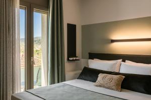 een slaapkamer met een bed en een groot raam bij APARKTION THE ZEPHYRUS STUDIO in Lixouri