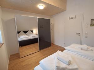 a bedroom with two beds and a mirror at Haus Wiesenquelle - Fewo 14 "Timeout", Feldberg in Feldberg