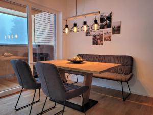 a dining room with a wooden table and chairs at Haus Wiesenquelle - Fewo 14 "Timeout", Feldberg in Feldberg