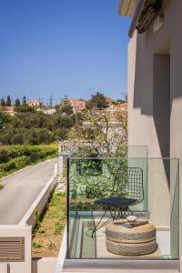 een glazen balkon met een tafel en een stoel bij APARKTION THE ZEPHYRUS STUDIO in Lixouri