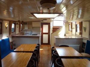 Una habitación con mesas y sillas de madera en un vagón de tren. en Uniek verblijf op slaapschip (tot 20 personen) nabij het centrum van Leeuwarden, en Leeuwarden 19 fotos más