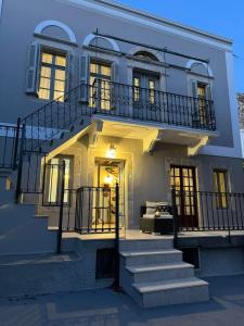 ein großes weißes Gebäude mit einer Treppe und einem Balkon in der Unterkunft OURANIAS HOUSE in Kalymnos