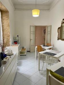 una cucina e una sala da pranzo con tavoli e sedie bianchi di Dimora Montecchi a Verona