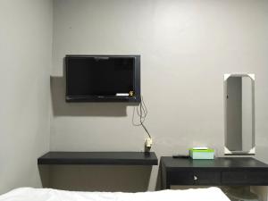 1 dormitorio con TV en la esquina de una pared en Roemah Tebet en Yakarta