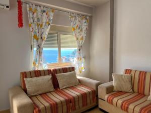 a living room with two couches and a window at Sea view apartment, Himara in Himare