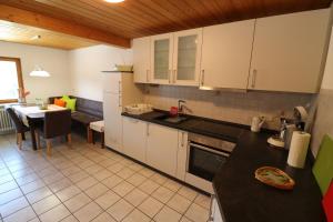 cocina con armarios blancos y mesa de comedor en Fewo Turmblick, en Oberried