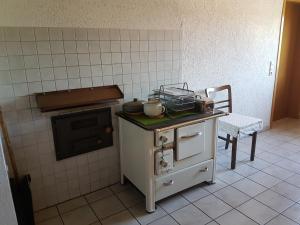 a kitchen with an old fashioned stove and a chair at Fewo Turmblick in Oberried