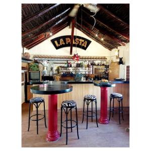 a restaurant with two tables and stools in front of a bar at La Bohemia in Mogán