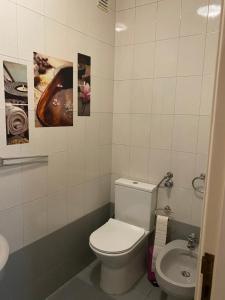 uma casa de banho com WC e um lavatório com fotografias na parede em Seventy na Póvoa do Varzim