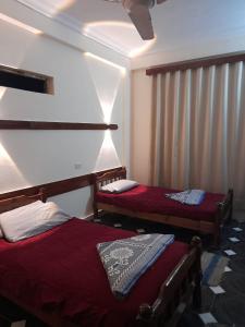 um quarto com duas camas e uma janela com cortinas em قريه جرين لاند العريش em El Arish