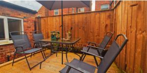 a patio with a table and chairs and an umbrella at Lovely Room in Modern House near Nottingham in Nottingham