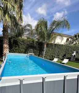 - une piscine dans une cour avec des palmiers dans l'établissement Villa Jari, à Carini