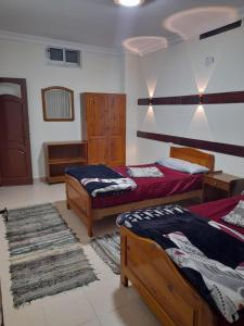 um quarto com 2 camas e um tapete em قريه جرين لاند العريش em El Arish