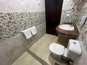 a bathroom with a toilet and a sink at Pyramids Masr in Cairo