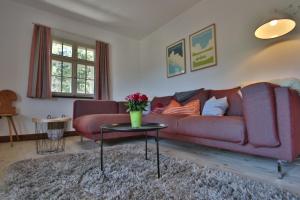 sala de estar con sofá rojo y mesa en Ferienhaus Matz, Feldberg, Hochschwarzwald, en Hinterfalkau