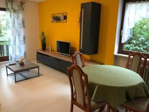 a living room with a table and a television at Fewo Sunneschii, Höchenschwand, Dorf am Himmel, Sauna im Haus in Höchenschwand