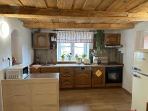 eine Küche mit Holzschränken und einem Fenster in der Unterkunft Chalupa u Žižky in Jiřetín pod Jedlovou