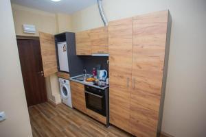 a small kitchen with wooden cabinets and a stove at Astonishing Studios in Veliko Turnovo in Veliko Tŭrnovo