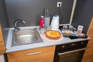 a kitchen counter with a sink and a plate of food at Turnovo Smart Studio - Cozy Work & Relax in Veliko Tŭrnovo