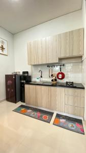 a kitchen with wooden cabinets and two mats on the floor at Mallory Villa in Batu
