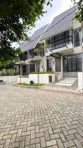 a house with a brick driveway in front of it at Mallory Villa in Batu