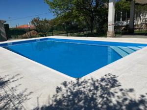 a large blue swimming pool in a yard at Tres Hermanos CON PISCINA PRIVADA in Pelabravo