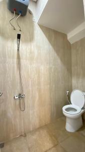 a bathroom with a toilet and a shower stall at Mallory Villa in Batu +5 photos