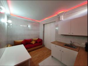 Studio Cosy moderne et climatisé في الرباط: مطبخ مع أريكة حمراء في الغرفة