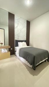 a bedroom with a large bed and a mirror at Mallory Villa in Batu