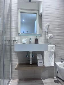 a white bathroom with a sink and a mirror at Nonna Maria in Bari