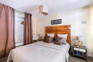 a bedroom with a large white bed with two lamps at Le Gîte de Sandra in Ribeauvillé +46 photos