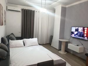 a bedroom with a bed and a flat screen tv at Alis Apartaments in Himare