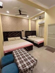 a bedroom with two beds and a couch in it at TEMPLE TOWN HOMES assi ghat Varanasi in Varanasi