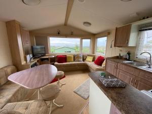 a kitchen and living room with a couch and a table at Caravan SK 110 in Leven
