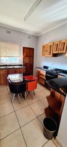 a kitchen with a table and a red table in it at ENTIRE LUXURY APARTMENTS in Mbabane