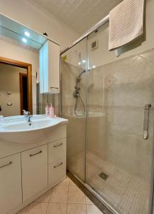 Un baño con ducha de cristal y lavabo. en Il Siciliano Apartment Taormina, en Taormina