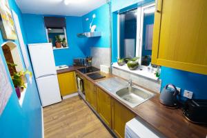uma cozinha com um lavatório e uma parede azul em 3 Bedroom home by Ipswich docks. em Ipswich