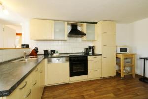 a kitchen with white cabinets and a stove top oven at Ferienwohnung Landleben im Dorfkrug Altglashütten- Feldberg in Feldberg +16 photos