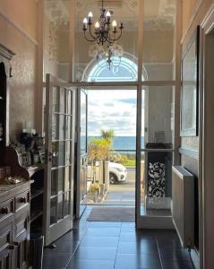 a kitchen with an open door with a view of the ocean at Promenâd Bed & Breakfast in Llandudno